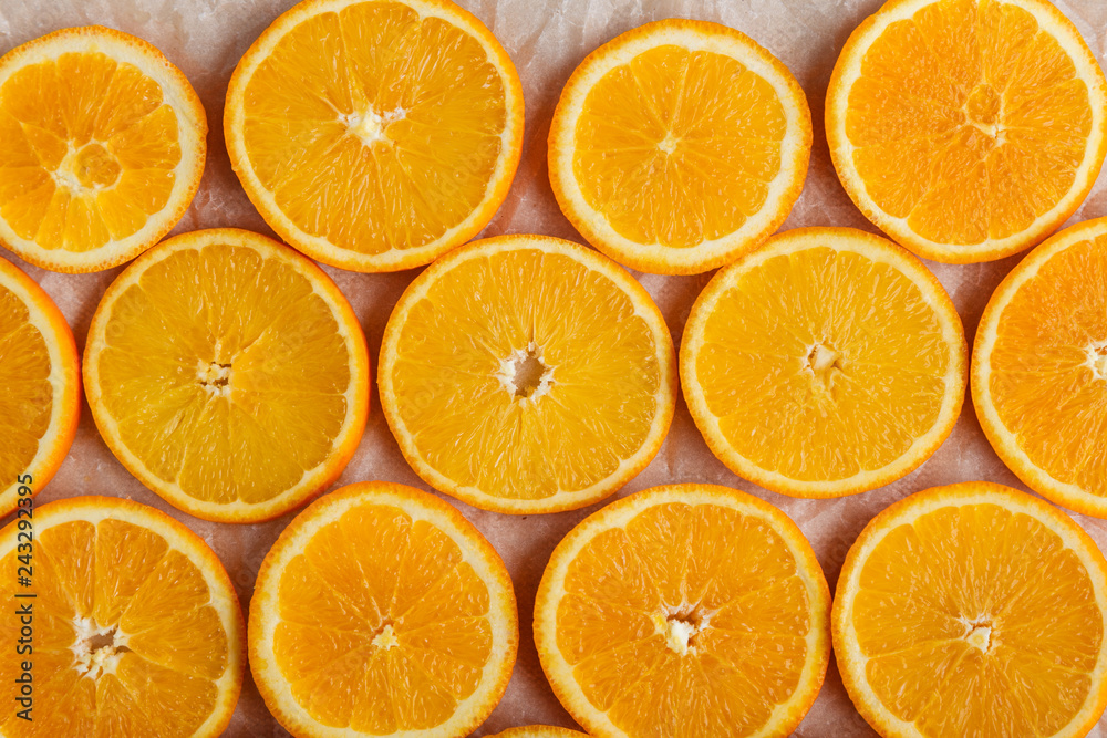 Abstract background with citrus orange slices on parchment paper. Close up. Top view. Studio photography.