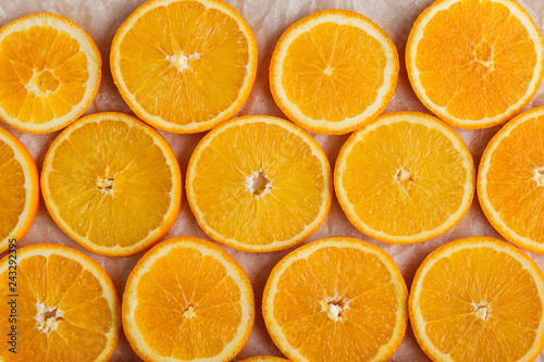 Abstract background with citrus orange slices on parchment paper. Close up. Top view. Studio photography.