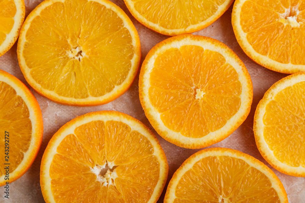 Abstract background with citrus orange slices on parchment paper. Close up. Top view. Studio photography.