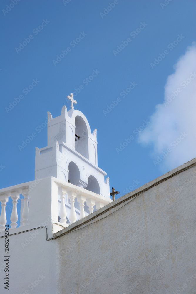 Bell tower of a traditional whitewashed church, Oia, Santorini, Greece.