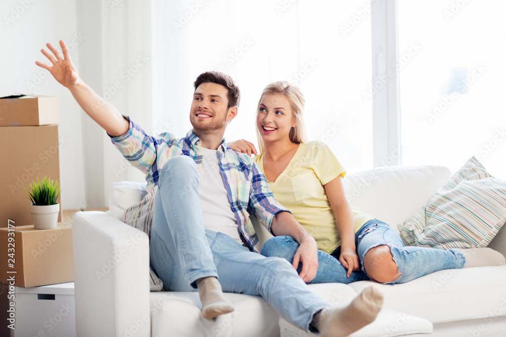 moving, people, repair and real estate concept - happy couple with big cardboard boxes on sofa at new home moving, people, repair and real estate concept - happy couple with big cardboard boxes on sofa at new home
