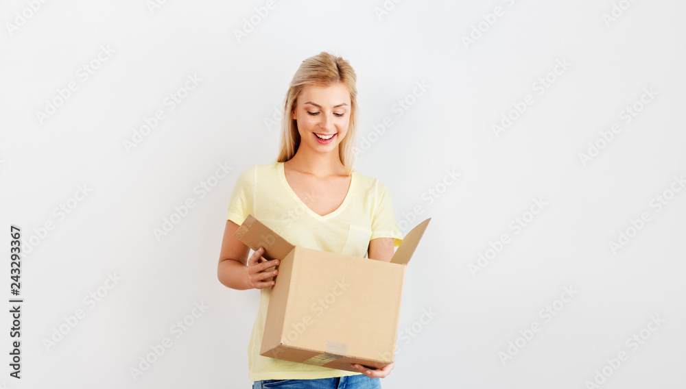 people and moving to new place concept - happy woman looking inside cardboard box people and moving to new place concept - happy woman looking inside cardboard box