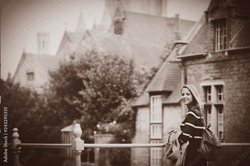 Obraz premium young girl in red sweater at streets of Bruges. Belgium, Atumn season Image in sepia color style