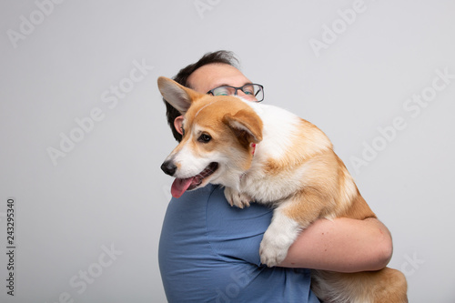 Adult man hold corgi dog