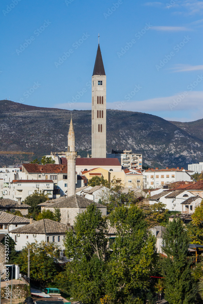 The bell tower of the Franciscan monastery over the roofs of dwelling houses in the town of Mostar. Bosnia and Herzegovina