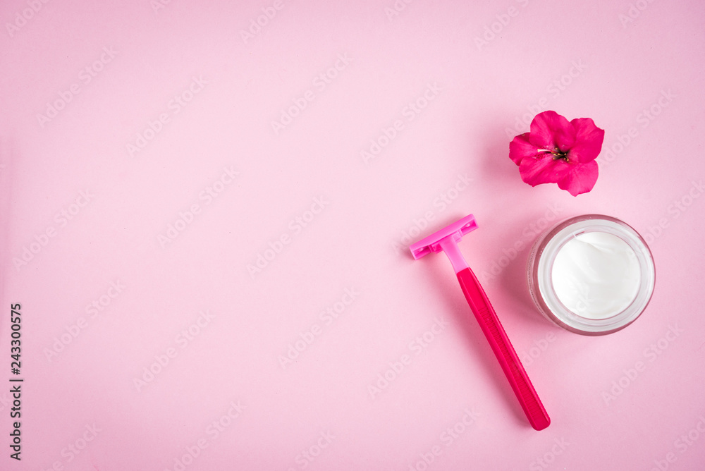Towel, cream, razor and flower on pink background. Flat lay. Skincare.