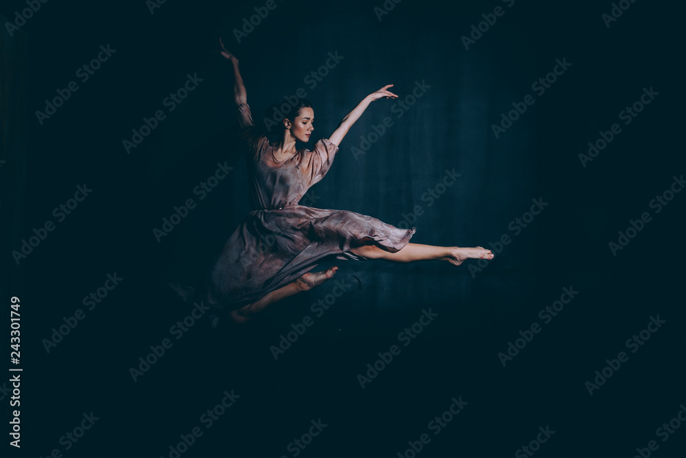 Ballet dancer in a jump on a black background