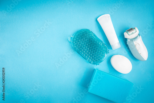 Blue bathroom feminine table. Soap, sponge, masseur, cream and depilator. Bath products. Cleansing and skincare. 
