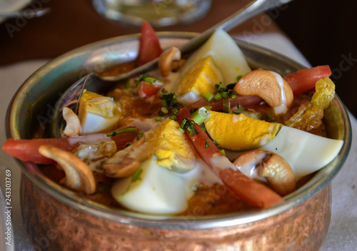Delicious Indian cuisine in a bronze pot. Traditional North-Indian masala-dish with extra ingredients.