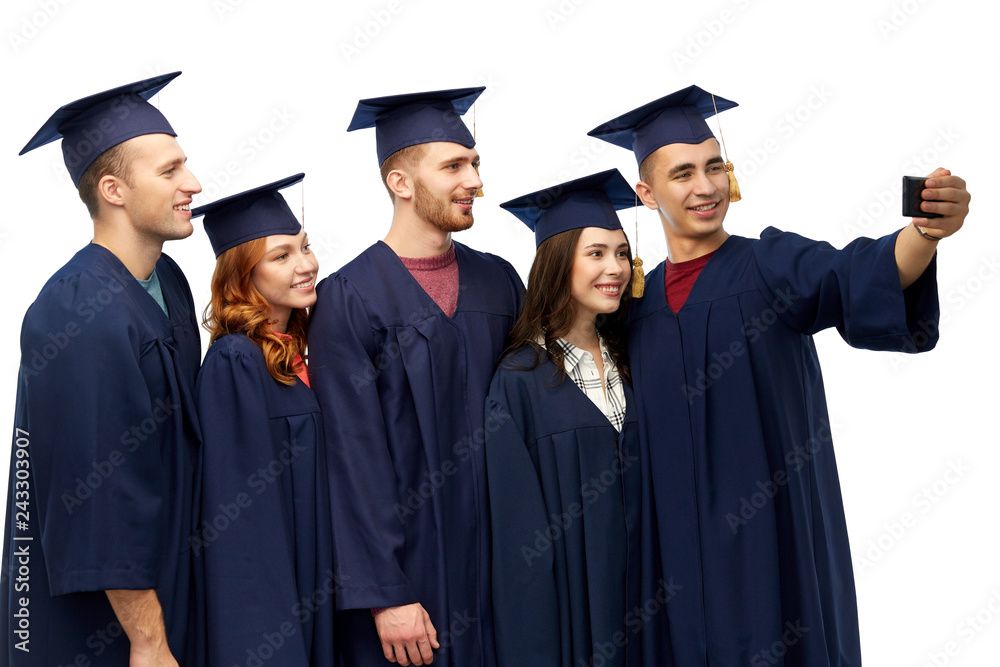 education, graduation and people concept - group of happy graduate students in mortar boards and bachelor gowns taking selfie by smartphone over white background education, graduation and people concept - group of happy graduate students in mortar boards and bachelor gowns taking selfie by smartphone over white background