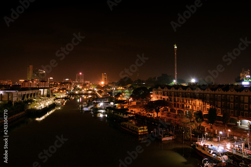 City of Malacca, Malaysia. Night view from a bridge. River flowing beneath.
