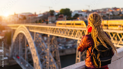 Woman with gold dreadlocks opposite the Dom Luis I bridge in Porto - Portugal.