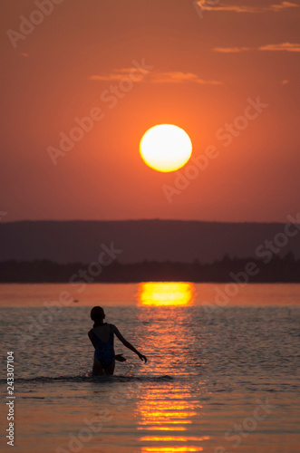 Children swim in the river at sunset. © Eugene