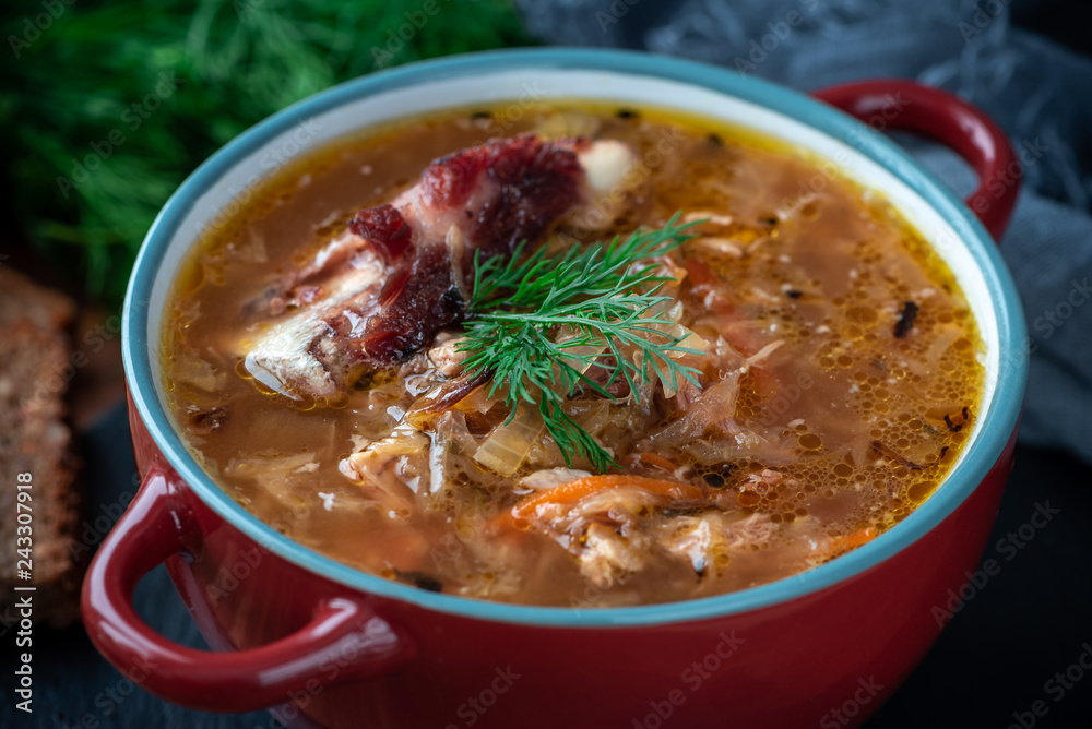 Soup in a plate on a dark wooden background. Russian cabbage soup. Soup in a plate on a dark wooden background. Russian cabbage soup.