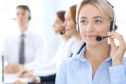 Call center. Group of operators at work. Focus at blonde business woman in headset © rogerphoto