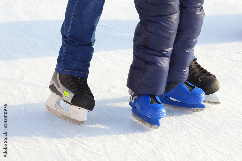 feet of different people skating on the ice rink feet of different people skating on the ice rink
