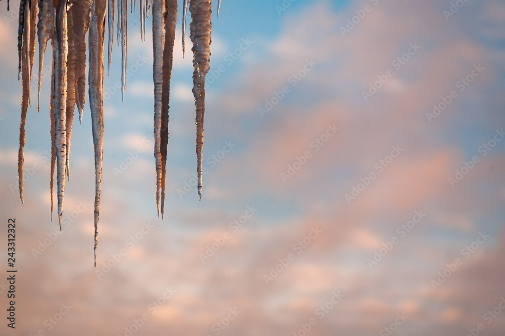 icicle on the edge of the roof with sky background sunset light icicle on the edge of the roof with sky background sunset light