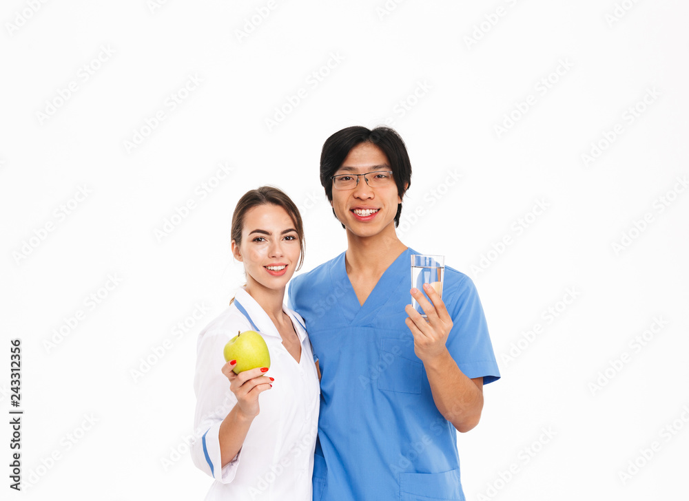 Smiling doctors couple wearing uniform standing Smiling doctors couple wearing uniform standing