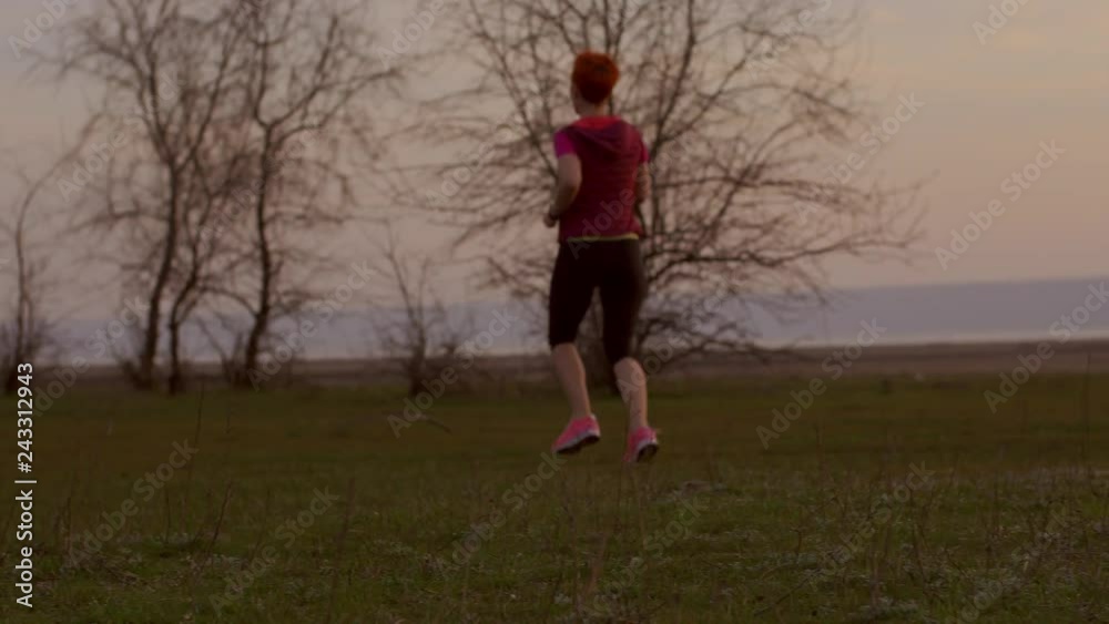 Young woman running at sunrise. Fitness runner girl training outdoors at sunset on amazing landscape nature. Fit athletic female working out for marathon, run outside. Sport and healthy lifestyle. Young woman running at sunrise. Fitness runner girl training outdoors at sunset on amazing landscape nature. Fit athletic female working out for marathon, run outside. Sport and healthy lifestyle.