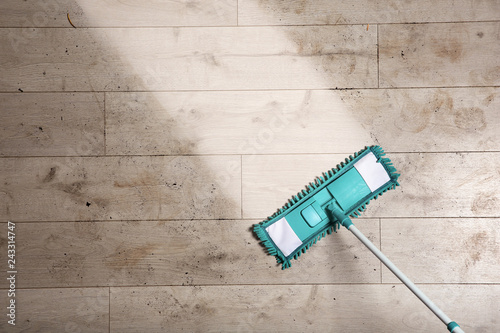 Cleaning wooden floor with mop, top view. Space for text