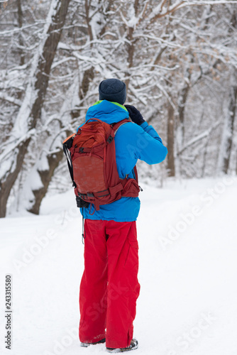 Happy man, traveler walking in the winter forest