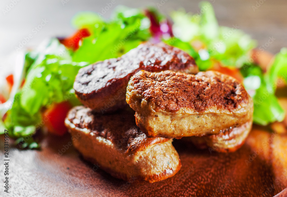 roasted sausages and various fresh mix salad leaves with tomato in plate on wooden table background