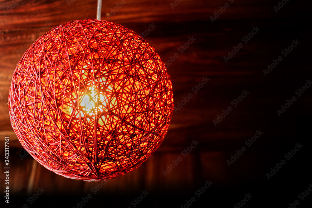 Obraz premium Close-up View of a red pendant lamp - twine lamp - glowing bulb