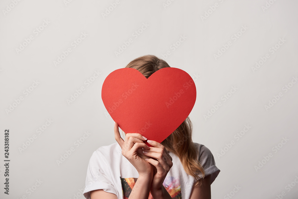 young woman with obscure face and empty paper cut heart card isolated on grey young woman with obscure face and empty paper cut heart card isolated on grey