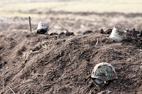 Valokuva soldier's helmet of protective color lies on the ground, in the background of th