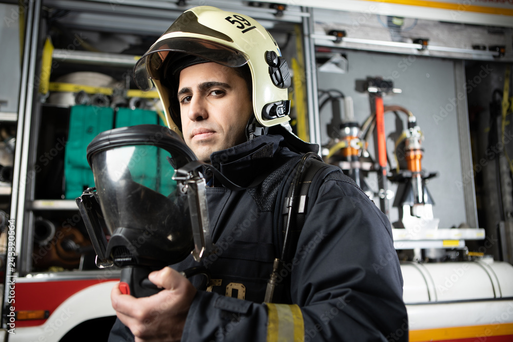 Photo of fireman man in helmet at fire truck Photo of fireman man in helmet at fire truck
