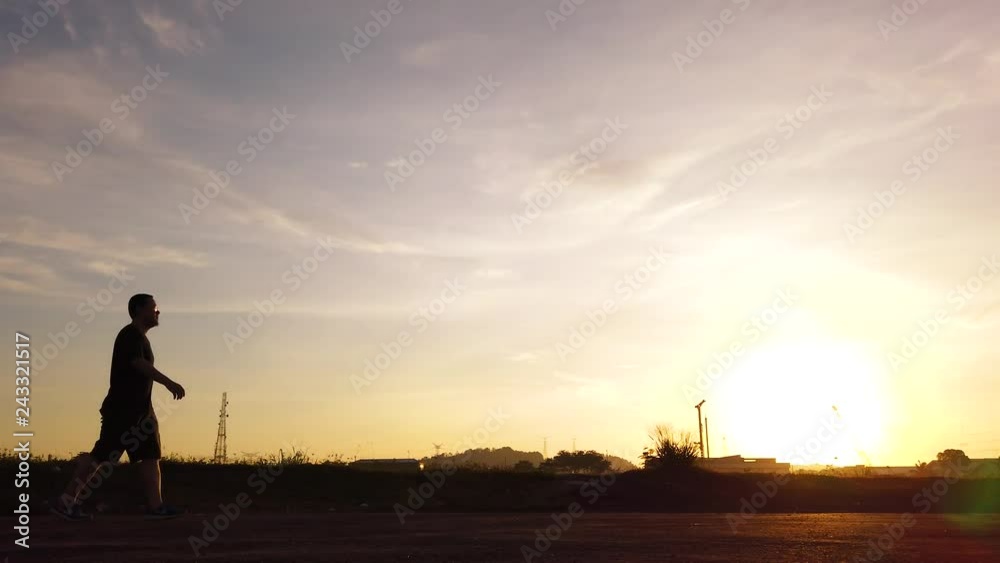 Silhouette of young man walking in summer sunrise sky outdoor. Lifestyle healthy concept . Silhouette of young man walking in summer sunrise sky outdoor. Lifestyle healthy concept .