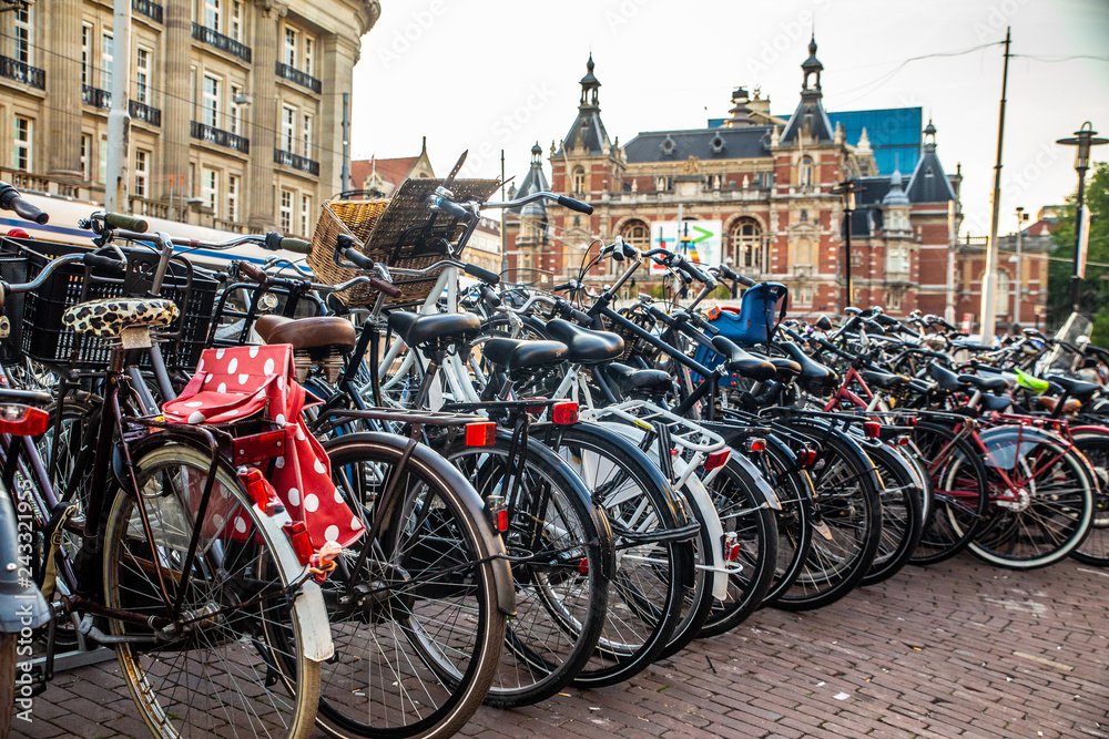 View of bicycles along street in Amsterdam with historic Stadsschouwburg building in the background