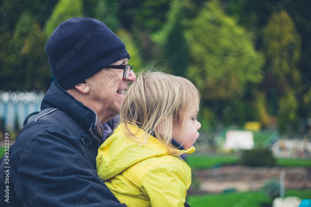 Toddler and grandfather in garden with model houses Toddler and grandfather in garden with model houses