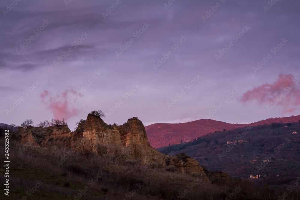 landscape with mountains and clouds, le balze del valdarno in tuscany at sunset