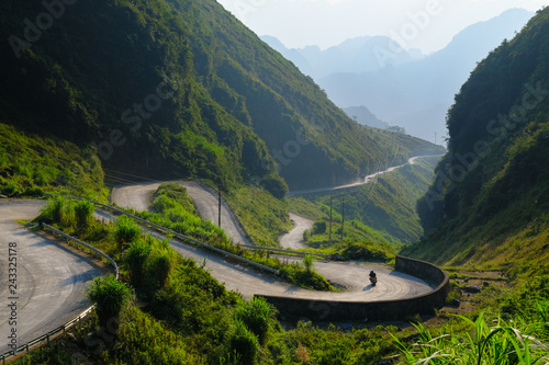 Motorbikers on winding roads through valleys and karst mountain scenery in the North Vietnamese region of Ha Giang / Dong Van.