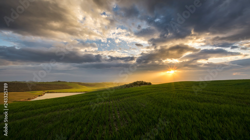 stunning sunset over green field in tuscany