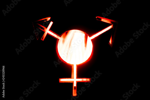 Image of a transgender symbol on a black background. Bokeh effect