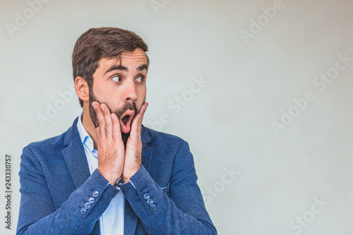 Business partner in a blue jacket. With a look of amazed businessman. Good looks. On a gray background.