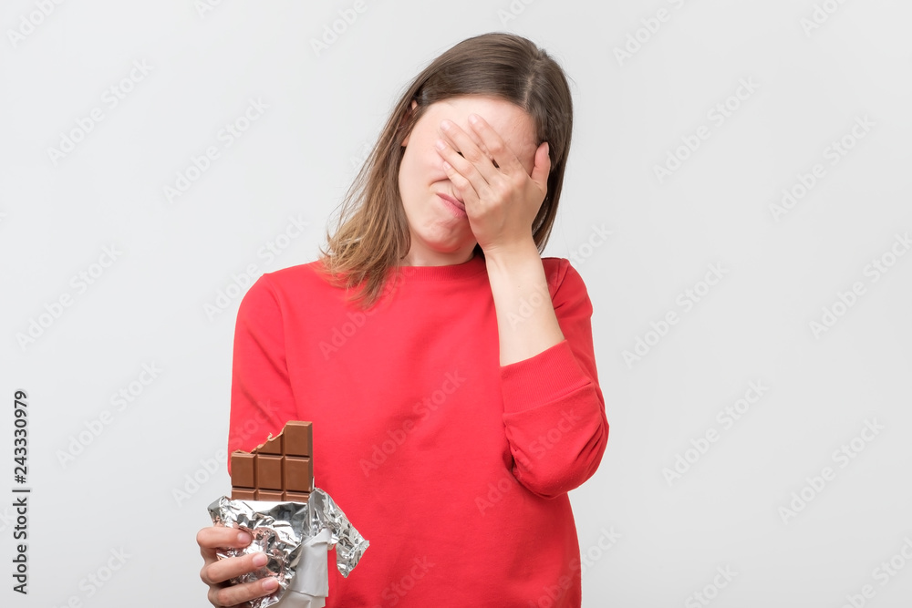© Viktor Koldunov - Sad young woman tired of diet restrictions holding sweet chocolate © Viktor Koldunov - Sad young woman tired of diet restrictions holding sweet chocolate