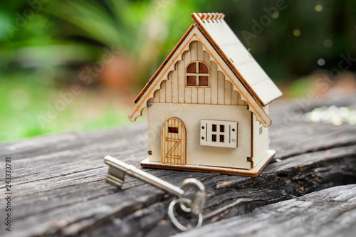 Closeup of house model and keys on wooden table