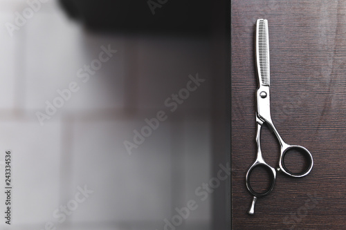 scissors for highlighting on a dark wooden table. Hairdressing Workspace. Work place for hairdresser. Professional Salon Supplies. Hair. Place for text. copy space