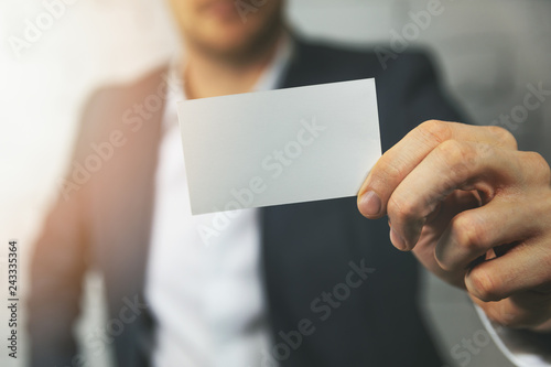 man hand showing blank white business card in front photo