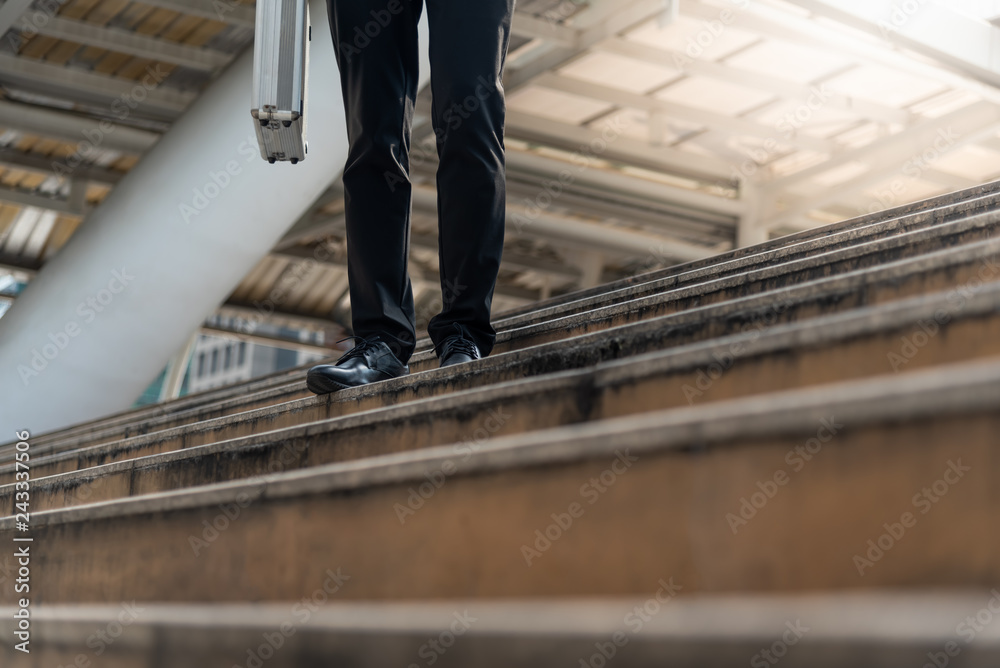 Businessman carrying a briefcase walk up stair To discuss business in the downtown, to successful concept Businessman carrying a briefcase walk up stair To discuss business in the downtown, to successful concept