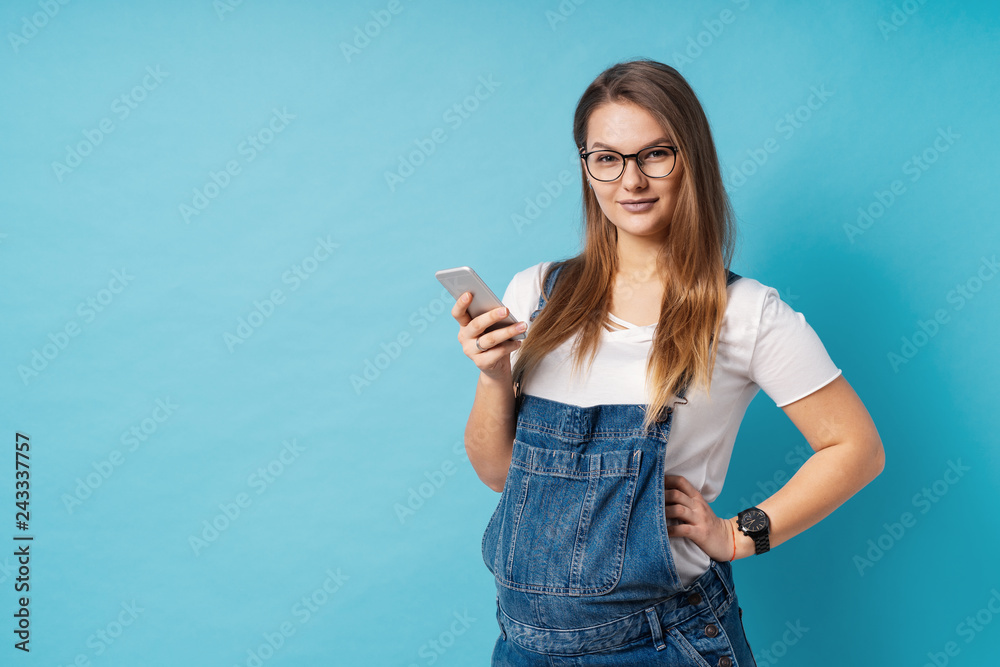 Smiling pregnant woman, with glasses, holding a mobile phone in Smiling pregnant woman, with glasses, holding a mobile phone in