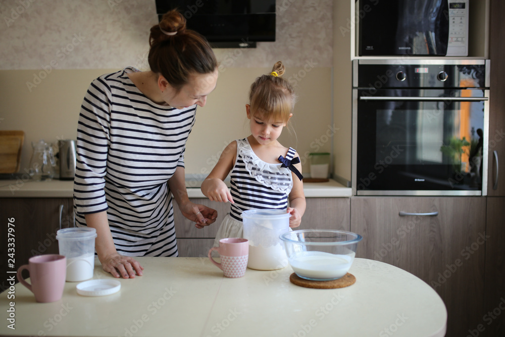 Funny daughter and mother cook together in kitchen Funny daughter and mother cook together in kitchen