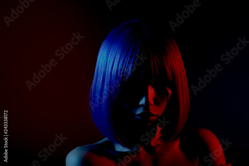 Woman in colorful bright lights posing in studio, portrait of beautiful sexy girl.