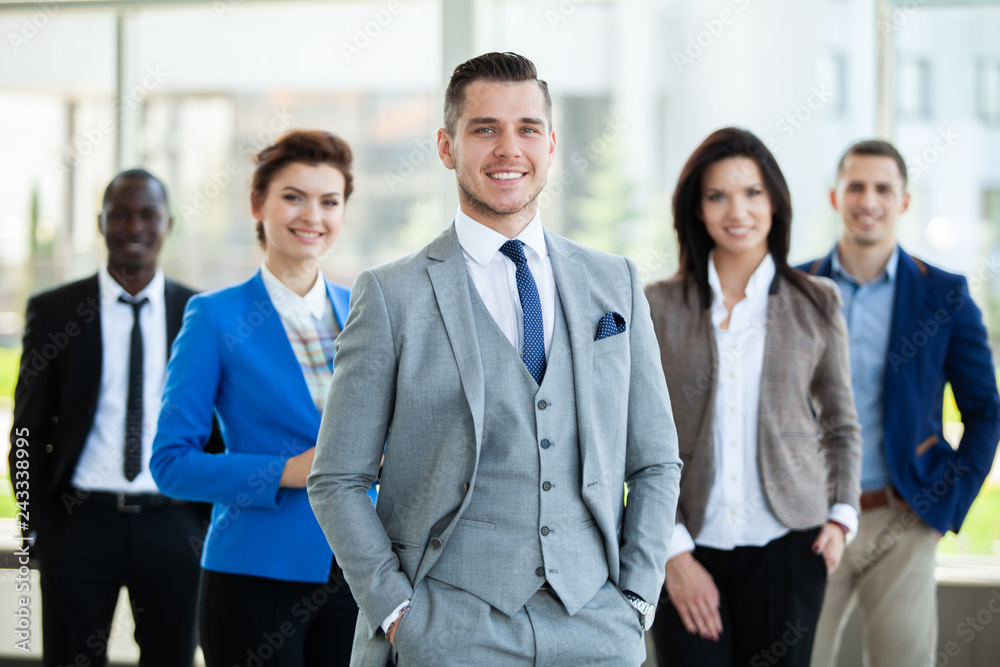 Happy smart business man with team mates discussing in the background. Happy smart business man with team mates discussing in the background.