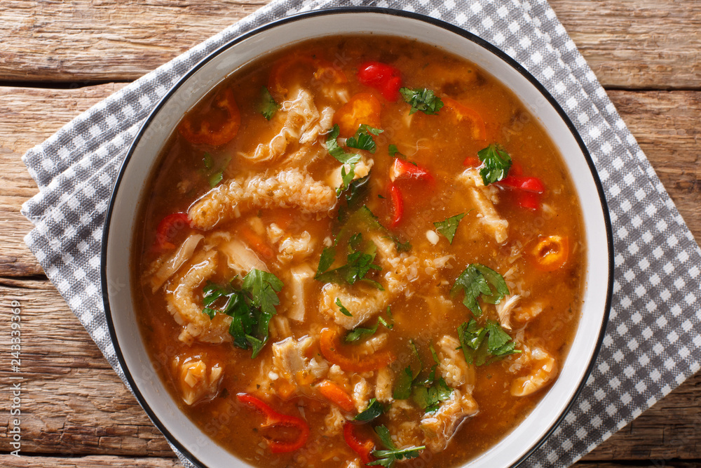 Dietary Polish meal flaczki with vegetables in tomato sauce close-up in a bowl. Horizontal top view