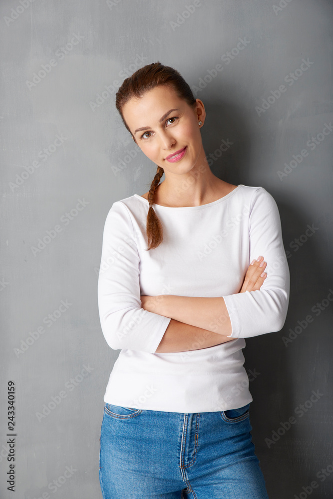 Smiling young female portrait. Beautiful woman standing against isolated grey background Smiling young female portrait. Beautiful woman standing against isolated grey background
