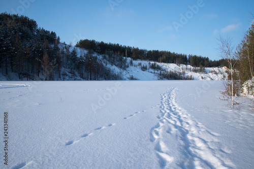 Sunny weather. Path on a snowy lake.